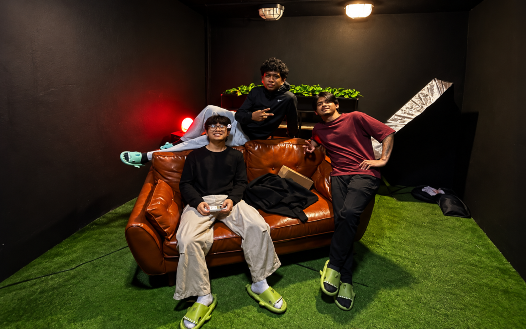 Three members of the TMR Media production team relaxing on a studio set between content shoots